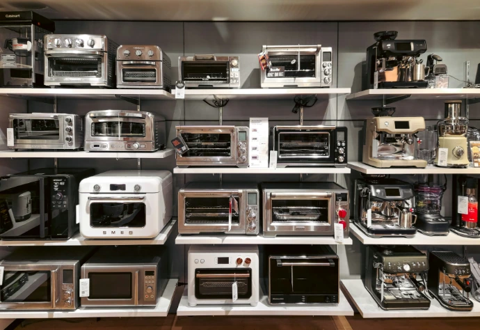 A bunch of microwaves that are on a shelf